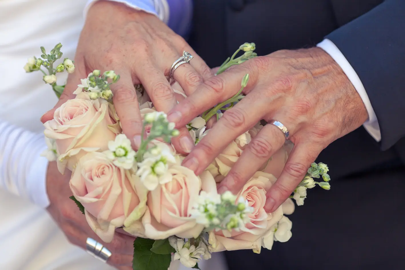 Les mains des mariés sont posées sur le bouquet pour mettre les alliances en valeur. type de Photo de mariage en corrèze posée